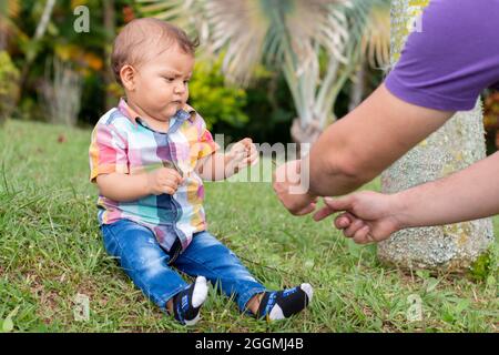 Bébé jouant dans un jardin plein de nature avec son père Banque D'Images