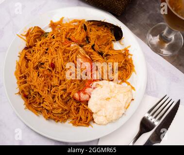 Fideua de fruits de mer espagnols, paella de nouilles avec aïoli Banque D'Images