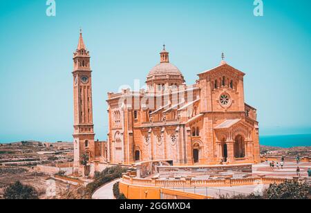 GOZO, MALTE - 09 août 2021 : une journée d'été lumineuse avec la magnifique basilique de Ta' Pinu au loin sous un ciel bleu clair Banque D'Images