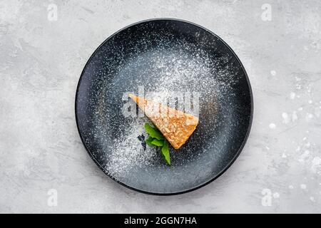 Vue de dessus d'un morceau triangulaire de gâteau au fromage caramel sur une assiette Banque D'Images