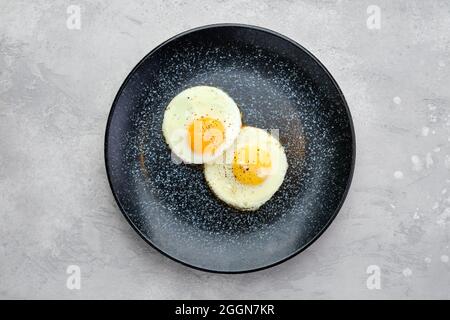 Vue de dessus de deux œufs frits sur une assiette Banque D'Images