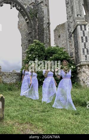 quatuor de femmes fantômes en blanc marchant d'une ruine d'église. Banque D'Images