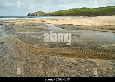 Détails fluviaux sur une plage où la tourbe est lavée dans le sable et la marée crée de beaux motifs. Reef Beach dans l'île de Lewis. Banque D'Images