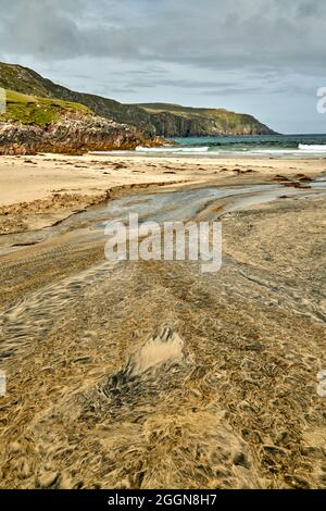 Détails fluviaux sur une plage où la tourbe est lavée dans le sable et la marée crée de beaux motifs. Reef Beach dans l'île de Lewis. Banque D'Images