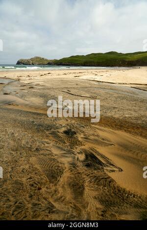 Détails fluviaux sur une plage où la tourbe est lavée dans le sable et la marée crée de beaux motifs. Reef Beach dans l'île de Lewis. Banque D'Images