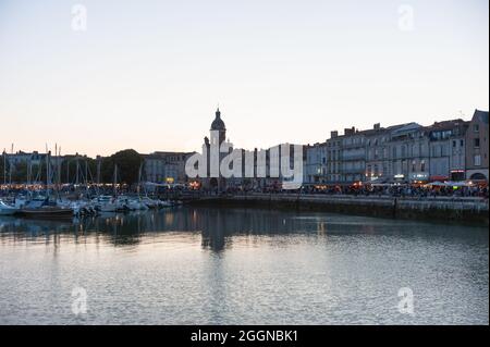 La Rochelle, France ; 10 août 2021 : vue sur le port médiéval de la Rochelle au crépuscule. Vous pouvez voir le port, les navires et la Tour de l'horloge. Banque D'Images