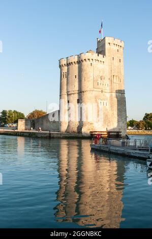 La Rochelle, France ; 10 août 2021 : Tour Saint-Nicolas à l'entrée du port de la Rochelle, France ; couronné par le drapeau français et réfléchi Banque D'Images