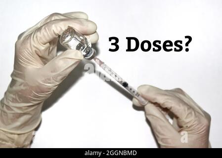 Image sélective des mains en gants blancs tenant la seringue et le flacon en verre, préparer l'injection avec le texte 3 doses? . Isolé sur fond blanc Banque D'Images