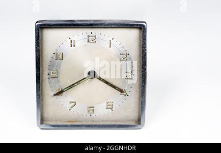 Ancienne horloge usée avec cadran carré isolé sur fond blanc. Mesure de temps analogique. Objet rétro et vintage. Copier l'espace. Banque D'Images