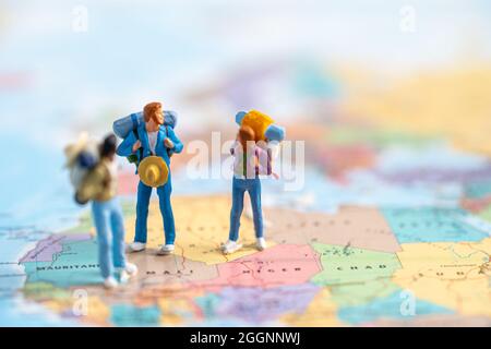 Les personnes miniatures, deux routards apprécient de découvrir voyage à l'incroyable sur la carte du monde. Banque D'Images