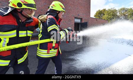 Arnstadt, Allemagne. 02 septembre 2021. Georg Maier (r., SPD), ministre de l'intérieur de la Thuringe, et Tino Otte (l), pompier, pratiquent avec de la mousse d'extinction à la nouvelle caserne de pompiers volontaires d'Arnstadt. Le ministre de l'intérieur avait déjà présenté ici le rapport de l'État sur la protection contre les incendies et les catastrophes pour l'année écoulée. Selon le ministère de l'intérieur, il montre, entre autres choses, à quelle fréquence les services d'incendie et autres sauveteurs de l'État libre sont appelés à une opération. Credit: Martin Schutt/dpa-Zentralbild/dpa/Alay Live News Banque D'Images