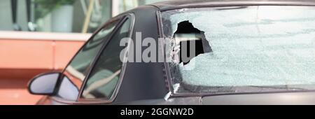 Gros plan de la lunette arrière cassée d'une voiture noire Banque D'Images