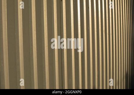 La texture de la clôture métallique. Acier inoxydable au soleil. Arrière-plan à profil en acier simple. Banque D'Images