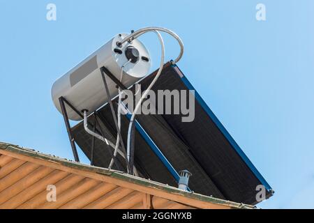 Panneaux solaires et technologies modernes de chauffage de l'eau système de collecte sur le toit du bâtiment sur fond de ciel bleu. Banque D'Images