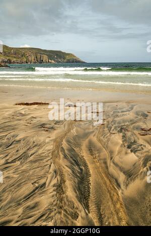 Détails fluviaux sur une plage où la tourbe est lavée dans le sable et la marée crée de beaux motifs. Reef Beach dans l'île de Lewis. Banque D'Images