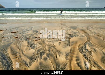 Détails fluviaux sur une plage où la tourbe est lavée dans le sable et la marée crée de beaux motifs. Reef Beach dans l'île de Lewis. Banque D'Images