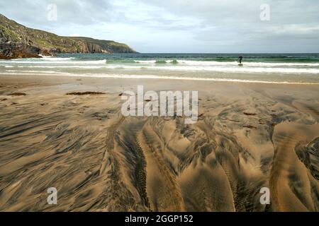 Détails fluviaux sur une plage où la tourbe est lavée dans le sable et la marée crée de beaux motifs. Reef Beach dans l'île de Lewis. Banque D'Images