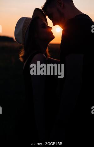 Silhouettes d'amoureux heureux dans les rayons du soleil sur la promenade romantique. Lune de miel. Bonheur et sérénité. Tendresse et romance. Coucher de soleil. Unité avec la nature.vie Banque D'Images