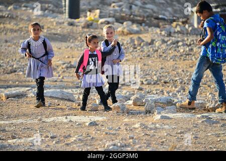 Depuis 2004, les enfants du village de Tuba se mettent à l'école dans le village voisin d'AT-Tuwani, A 2.6 km - tout en étant chaperé par un militant juif et un véhicule des forces de défense israéliennes afin des protéger des attaques violentes des colons juifs religieux contre l'avant-poste illégal de Maon Farm qui se trouve sur leur chemin vers l'école. Palestine/Israël, au sud d'Hébron. 31 août 2021. (Photo de Matan Golan/Sipa USA) crédit: SIPA USA/Alay Live News Banque D'Images