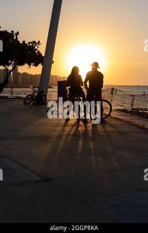 Jeune couple cycliste appréciant le coucher du soleil à Fortaleza Ceara Brésil Banque D'Images