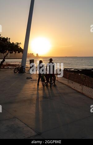 Jeune couple cycliste appréciant le coucher du soleil à Fortaleza Ceara Brésil Banque D'Images