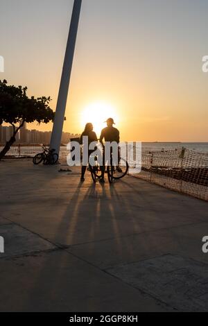 Jeune couple cycliste appréciant le coucher du soleil à Fortaleza Ceara Brésil Banque D'Images