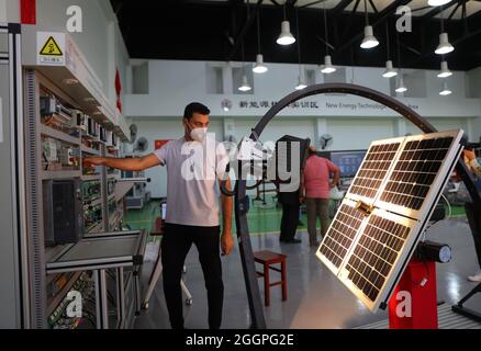 Le Caire, Égypte. 16 août 2021. Un stagiaire apprend la simulation d'un système de production hybride éolien-photovoltaïque à l'atelier de Luban de la zone de formation sur les nouvelles technologies énergétiques à l'Université Ain Shams au Caire, en Égypte, le 16 août 2021. POUR ALLER AVEC "Feature: L'atelier professionnel chinois en Egypte prépare les diplômés pour le marché du travail" crédit: Sui Xiankai/Xinhua/Alamy Live News Banque D'Images