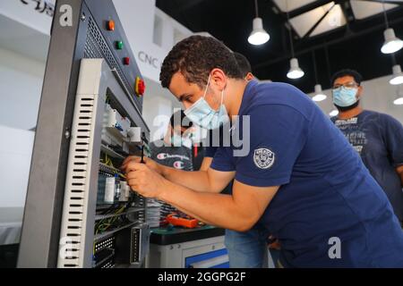 Le Caire, Égypte. 16 août 2021. Un stagiaire apprend la connexion de circuit à la zone de formation à l'installation et à la mise en service de la commande numérique d'ordinateur (CNC) de l'atelier Luban à l'Université Ain Shams au Caire (Égypte), le 16 août 2021. POUR ALLER AVEC "Feature: L'atelier professionnel chinois en Egypte prépare les diplômés pour le marché du travail" crédit: Sui Xiankai/Xinhua/Alamy Live News Banque D'Images