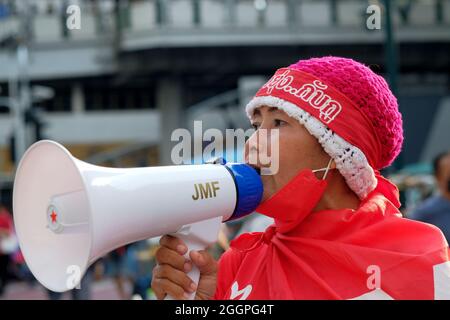 Bangkok, Thaïlande, 2 septembre 2021, une femme partisane du Front Uni pour la démocratie contre la dictature (UDD) crie au mégaphone aux côtés d'autres manifestants pour demander la démission du Premier ministre thaïlandais, le général Prayut Chan-ocha. La manifestation d'aujourd'hui a fermé les routes nord-sud de la jonction de la route d'Asoke dans le centre de Bangkok, et limité la circulation le long de la route de Sukhumvit. L'événement d'aujourd'hui faisait partie d'une série de manifestations en cours dans tout le pays pour exprimer la désaffection du gouvernement actuel pendant la pandémie de COVID. Banque D'Images