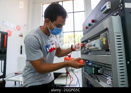 Le Caire, Égypte. 16 août 2021. Un stagiaire apprend la connexion de circuit à la zone de formation à l'installation et à la mise en service de la commande numérique d'ordinateur (CNC) de l'atelier Luban à l'Université Ain Shams au Caire (Égypte), le 16 août 2021. POUR ALLER AVEC "Feature: L'atelier professionnel chinois en Egypte prépare les diplômés pour le marché du travail" crédit: Sui Xiankai/Xinhua/Alamy Live News Banque D'Images