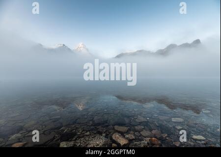 Mont Assiniboine dans un reflet brumeux bleu sur le lac Magog le matin au parc provincial, C.-B., Canada Banque D'Images