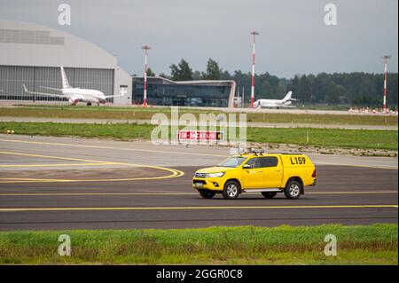 Riga, Lettonie - 31 août 2021 : voiture jaune de contrôle des oiseaux d'aviation à l'aéroport international de Riga (RIX) Banque D'Images