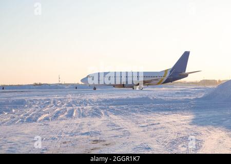 Avion de ligne sur piste en blizzard. Avion en train de rouler sur la piste d'atterrissage pendant une forte neige. Avion passager dans la neige à l'aéroport. Banque D'Images