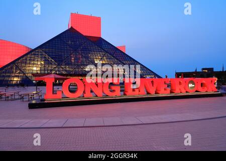 Vue au crépuscule sur le Rock and Roll Hall of Fame conçu par l'architecte I.M.PEI. Avec long Live Rock en premier plan.Cleveland.Ohio.USA Banque D'Images