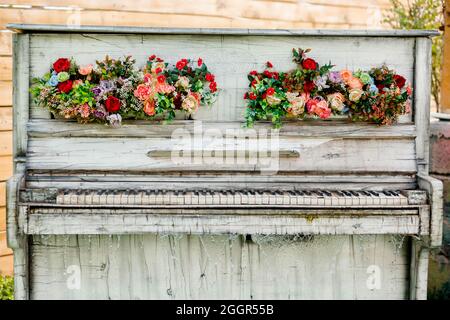 Piano blanc rétro décoratif extérieur avec ornements de fleurs et cascade d'eau Banque D'Images