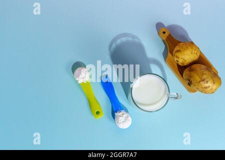 Lait de pomme de terre végétalien en poudre. Un verre de lait sur fond multicolore Banque D'Images