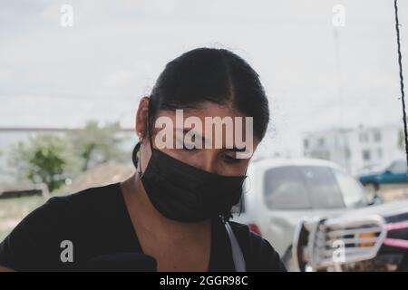 Portrait d'une femme avec un masque le jour du marché. Belmopan, Belize. Banque D'Images