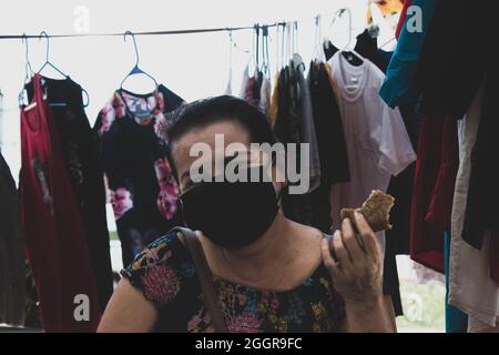 Portrait d'une femme vendeur de vêtements avec un masque le jour du marché. Belmopan, Belize. Banque D'Images