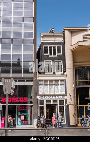 Amsterdam, pays-Bas - 13 août 2021 : avant de la boutique de cadeaux Heinen Delfts Blauw sur Damrak. Très petite maison historique avec un deuxième étage incliné Banque D'Images