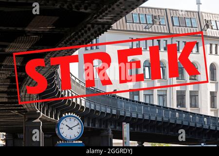 Bannière avec texte allemand Streik (signifiant grève) sur une image avec une horloge sous la courbe d'un pont de chemin de fer de banlieue dans la ville de Hambourg, en allemand Banque D'Images