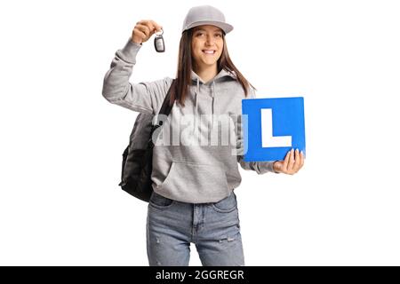 Adolescente portant une plaque d'apprentissage et une clé de voiture isolée sur fond blanc Banque D'Images