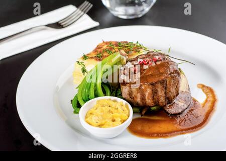 Filet de bœuf et risotto au basilic sur une assiette en porcelaine Banque D'Images