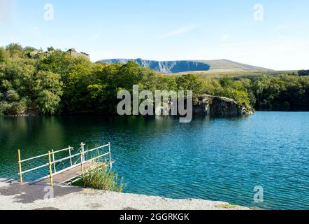 Belle carrière de Dorothea, Snowdonia, pays de Galles. Paysage paisible avec forêt, lac et une petite jetée en premier plan. Mine d'ardoise inondée et désexploitée Banque D'Images