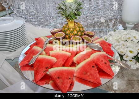 Assiette de fruits frais d'été en tranches. Melon, kiwi, pastèque, ananas, fruit de la passion Banque D'Images