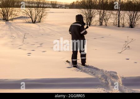 un chasseur à skis près des pistes de la tétras de bois qui déversait la nuit dans la neige recouverte de neige fraîche Banque D'Images