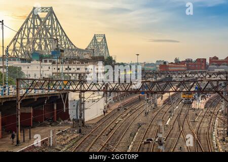 Pont de Howrah avec vue sur les voies ferrées et la plate-forme ferroviaire avec le paysage urbain distant de Kolkata au lever du soleil. Banque D'Images