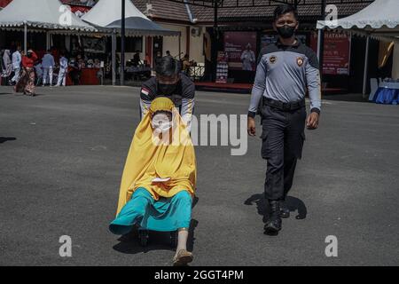 Makassar, Sulawesi du Sud, Indonésie. 3 septembre 2021. Un mendiant féminin qui est également une personne handicapée est pris par les policiers pour obtenir une vaccination Covid-19. Cette activité de vaccination gratuite a été effectuée au quartier général de la brigade mobile de la police de Sulawesi du Sud pour atteindre l'objectif de vaccination des Sulawesi du Sud, jusqu'à 80 pour cent. (Credit image: © Herwin Bahar/ZUMA Press Wire) Credit: ZUMA Press, Inc./Alamy Live News Banque D'Images