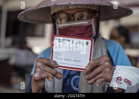 Makassar, Sulawesi du Sud, Indonésie. 3 septembre 2021. Un mendiant qui est également une personne handicapée montre une carte vaccinale qui a été obtenue après avoir effectué la vaccination Covdi-19 au quartier général de la brigade mobile de la police de Sulawesi Sud. Cette activité de vaccination gratuite a été effectuée au quartier général de la brigade mobile de la police de Sulawesi du Sud pour atteindre l'objectif de vaccination des Sulawesi du Sud, jusqu'à 80 pour cent. (Credit image: © Herwin Bahar/ZUMA Press Wire) Credit: ZUMA Press, Inc./Alamy Live News Banque D'Images