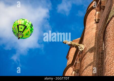 Albi, France. 8 août 2021. Détail de la façade de la cathédrale Albi. En arrière-plan, un ballon d'air chaud flous vole au-dessus de la ville. Banque D'Images