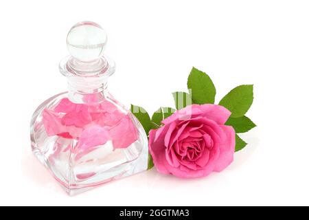 Bouteille d'eau de rose en verre art déco avec fleur. Maintient l'équilibre du pH de la peau, est antibactérien, réduit la rougeur de la peau, traite l'acné et la dermatite. Banque D'Images